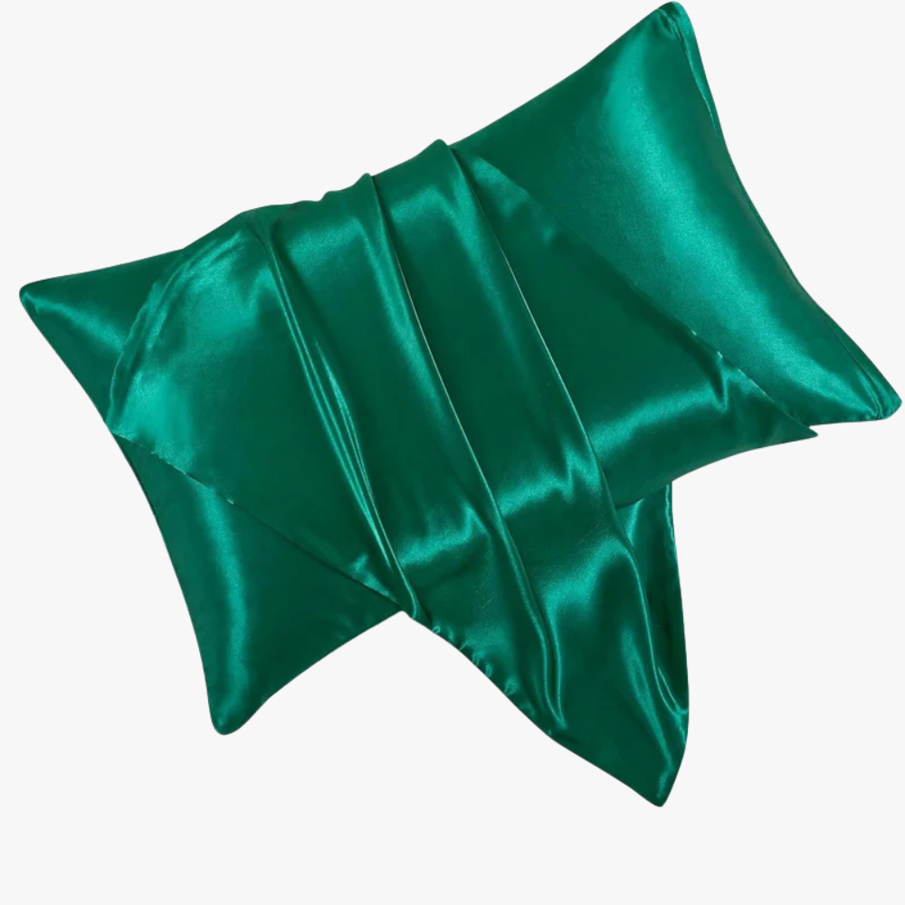 Green satin pillow on a white background
