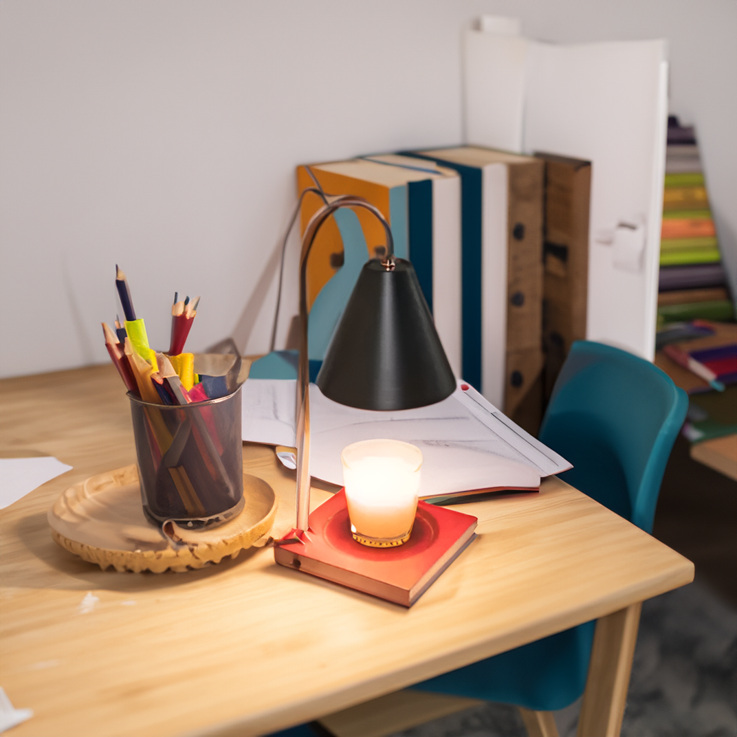 Desk with a lamp, candle, and pencil holder in an office setting