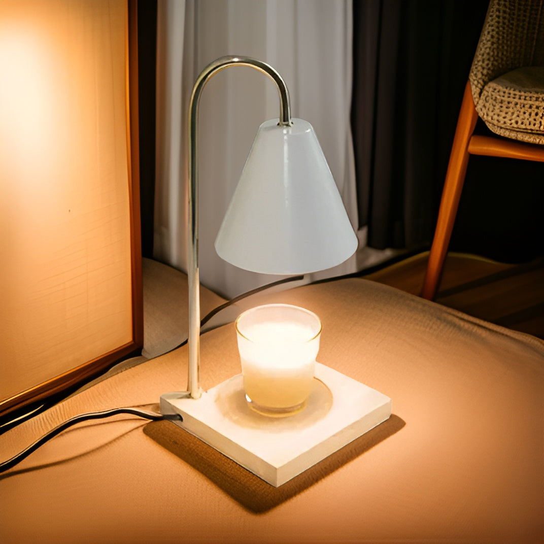 Table lamp with a white shade and candle on a wooden surface