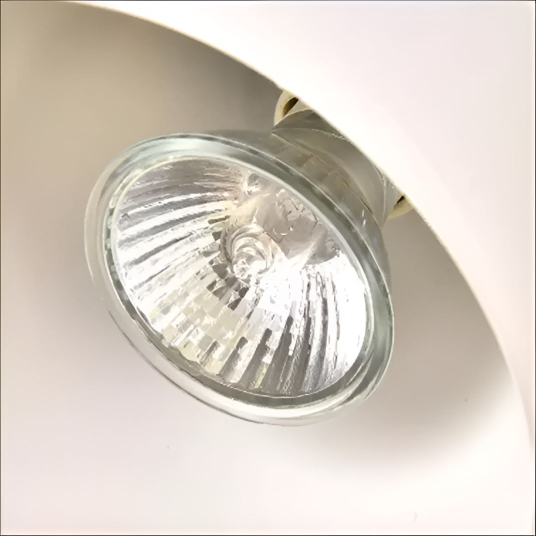 Close-up of a halogen light bulb in a metallic fixture on a white background