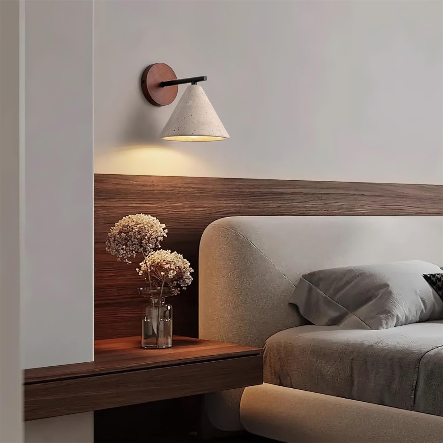 Modern bedroom with a wooden headboard, wall lamp, and decorative vase.