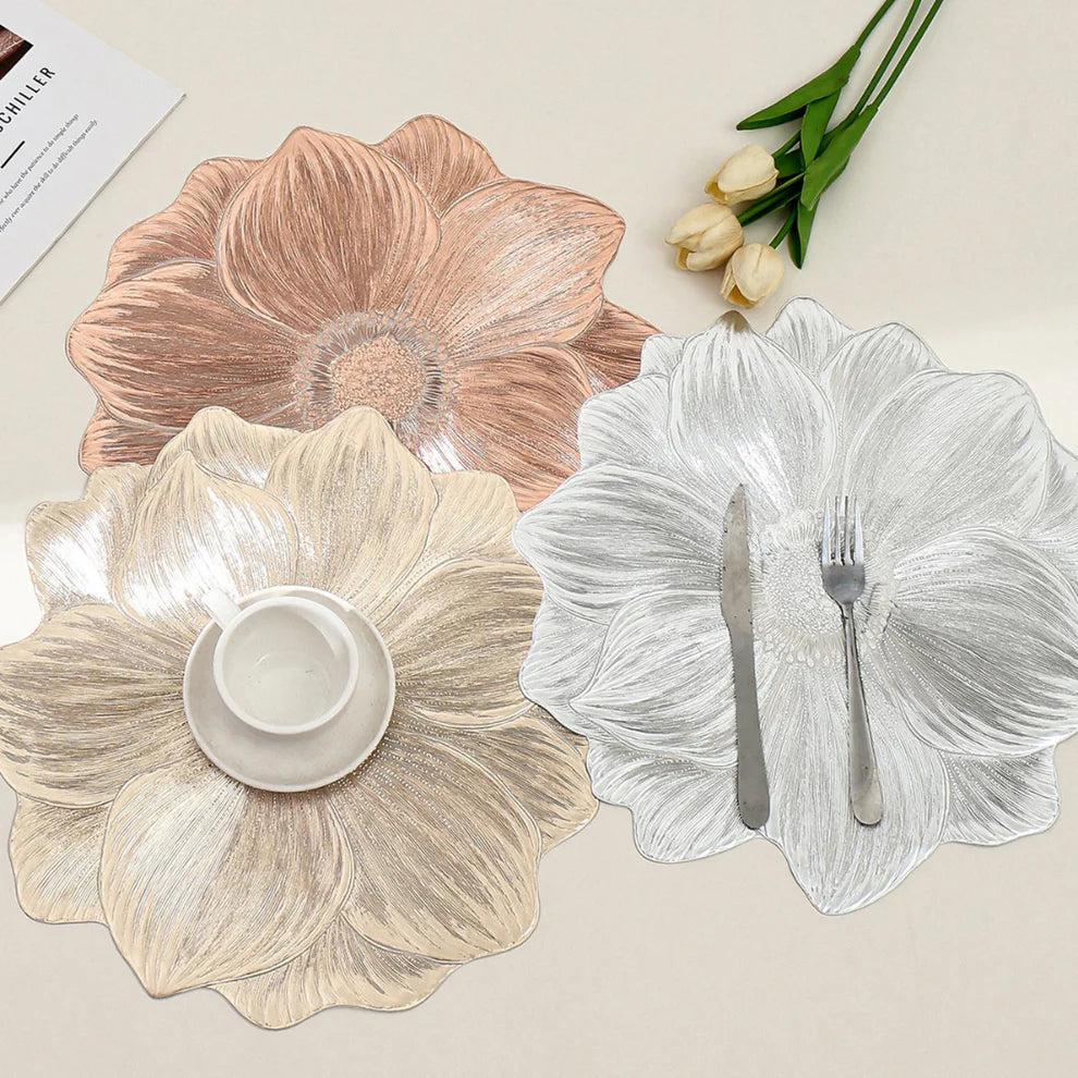 Floral-patterned placemats on a table with cutlery and tulips.
