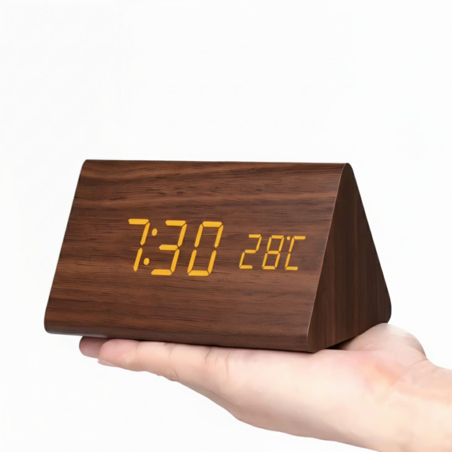 Wooden digital clock with orange LED display held in a hand against a white background