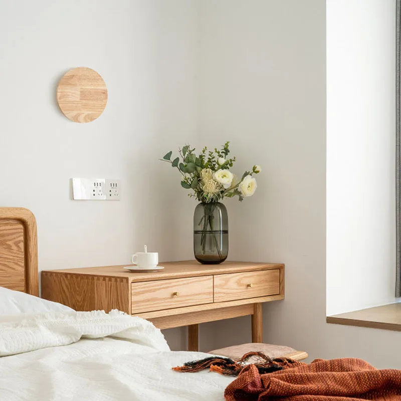 Wooden desk with a vase of flowers in a bedroom setting