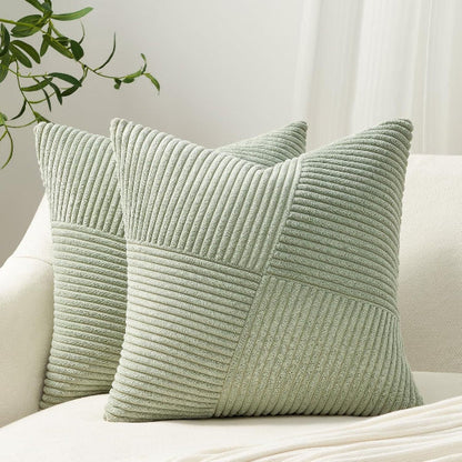 Two green textured pillows on a white sofa with a neutral background
