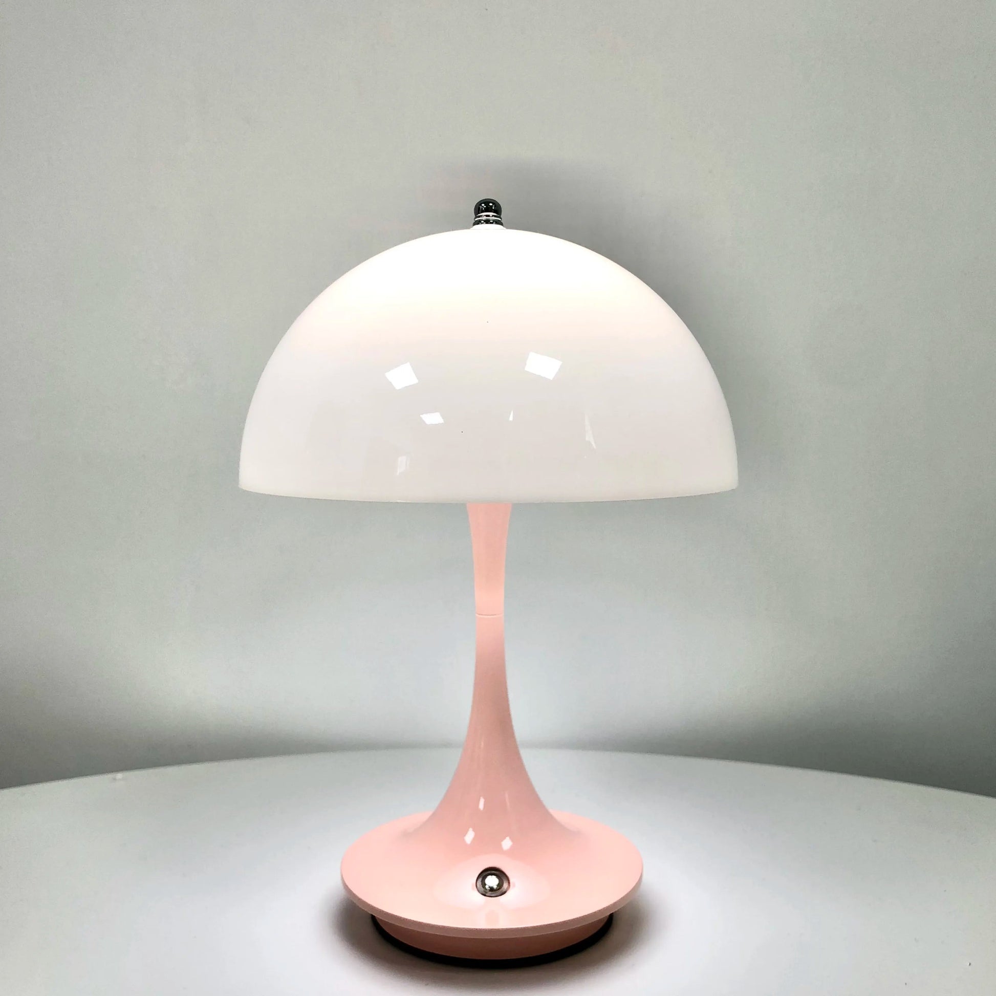 Pink table lamp with a white shade on a gray background