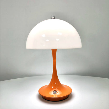 Table lamp with white shade and orange base on a gray background