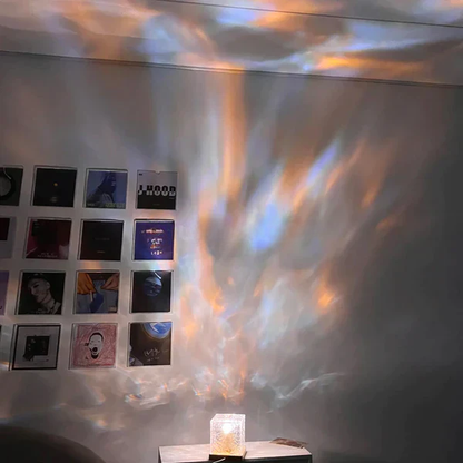 Wall with framed pictures and a colorful light projection on a ceiling.