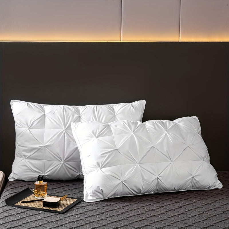 White quilted pillows on a bed with a dark headboard