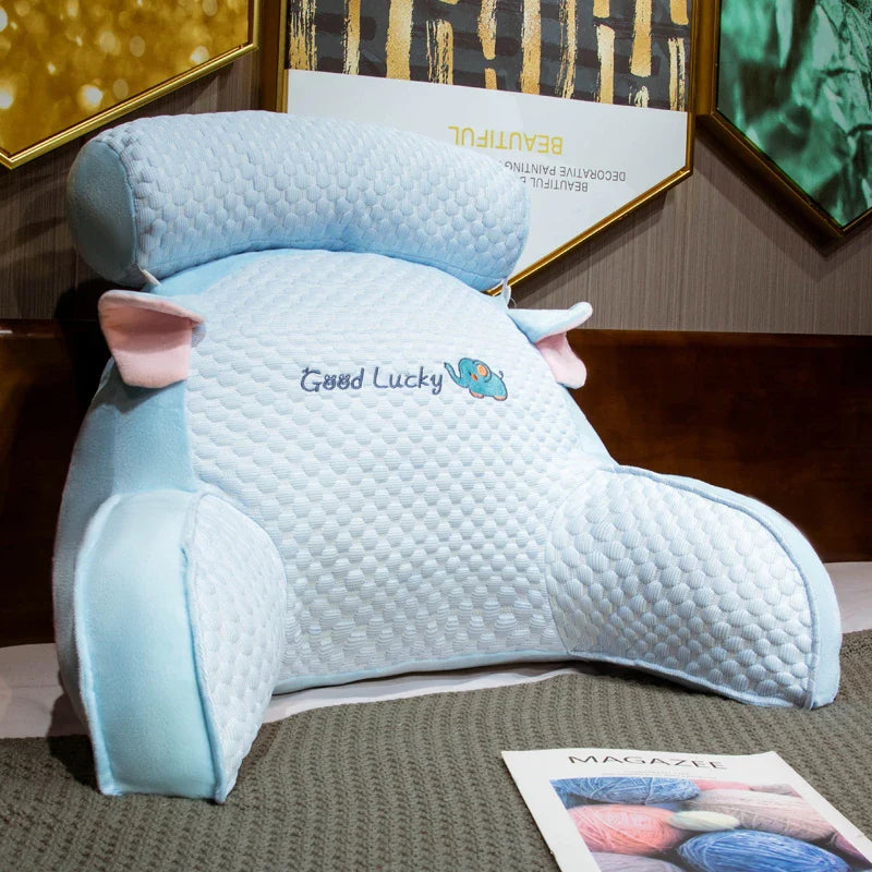 Blue pillow with 'Good Lucky' embroidery on a surface with framed pictures in the background