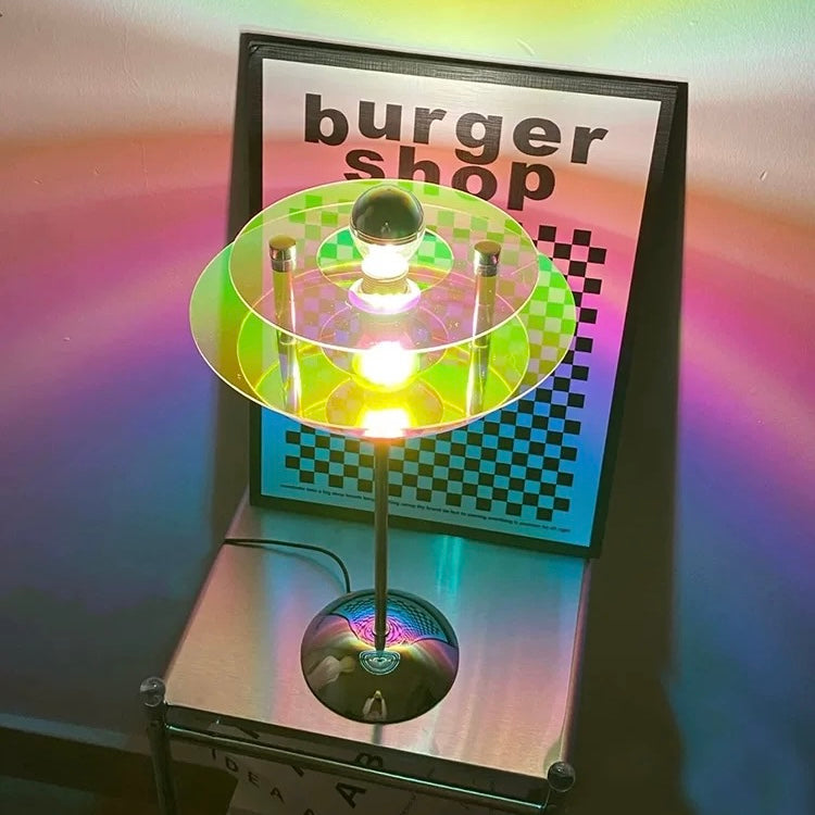 Colorful light-up spinner toy on a stand with a 'burger shop' sign in the background.